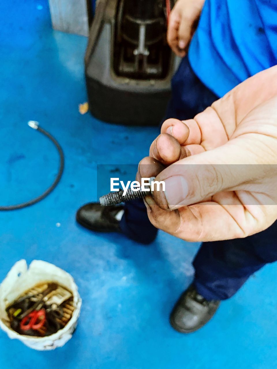 High angle view of man holding screw