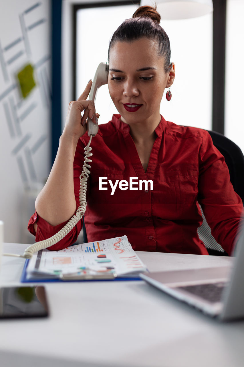 Businesswoman talking on phone at office