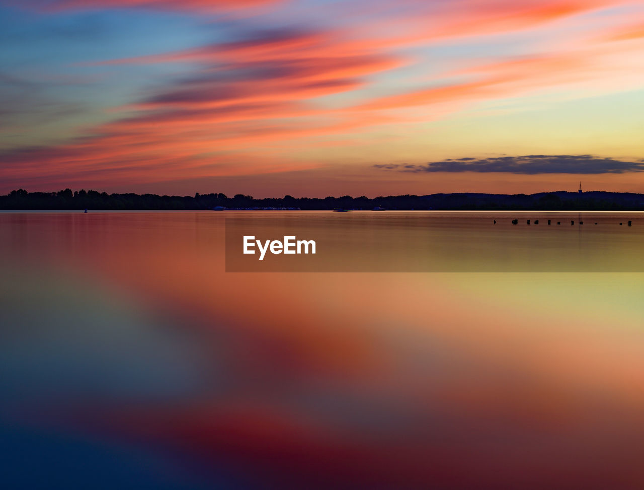 sky, sunset, water, cloud, beauty in nature, reflection, afterglow, scenics - nature, tranquility, horizon, nature, dawn, tranquil scene, orange color, no people, sea, dramatic sky, landscape, multi colored, environment, red sky at morning, evening, outdoors, idyllic, silhouette, sunlight, travel destinations, romantic sky