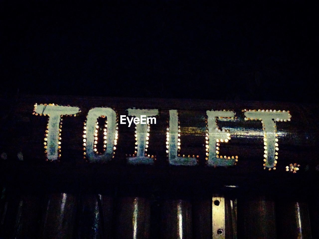 Low angle view of toilet sign at night