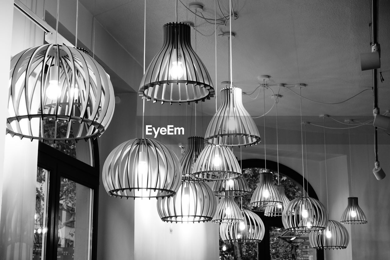 LOW ANGLE VIEW OF ILLUMINATED PENDANT LIGHTS HANGING AT HOME