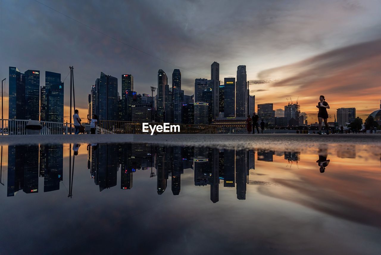 Reflection of buildings in city at sunset