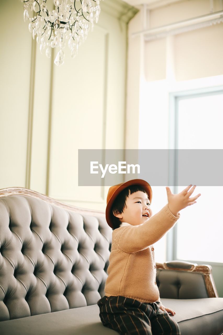 Boy sitting on sofa at home