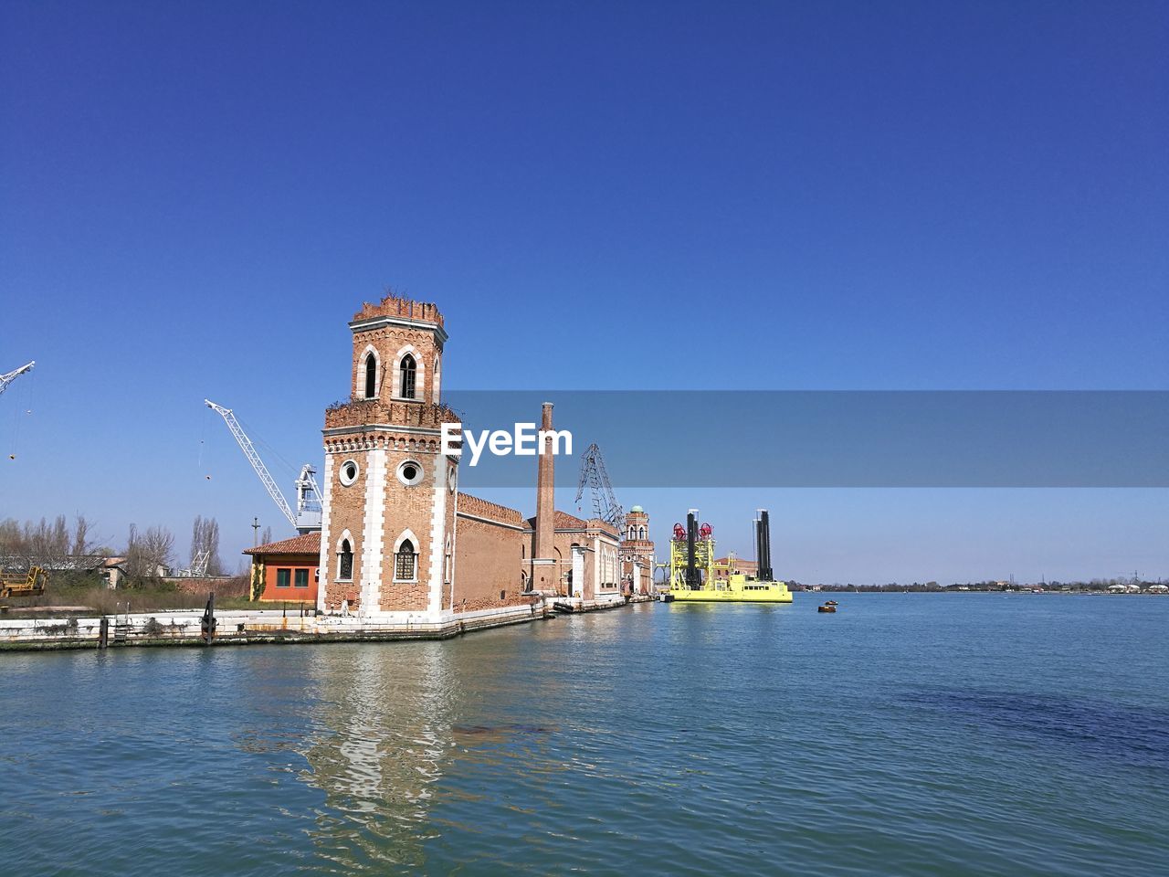 VIEW OF BUILDING BY SEA AGAINST CLEAR SKY