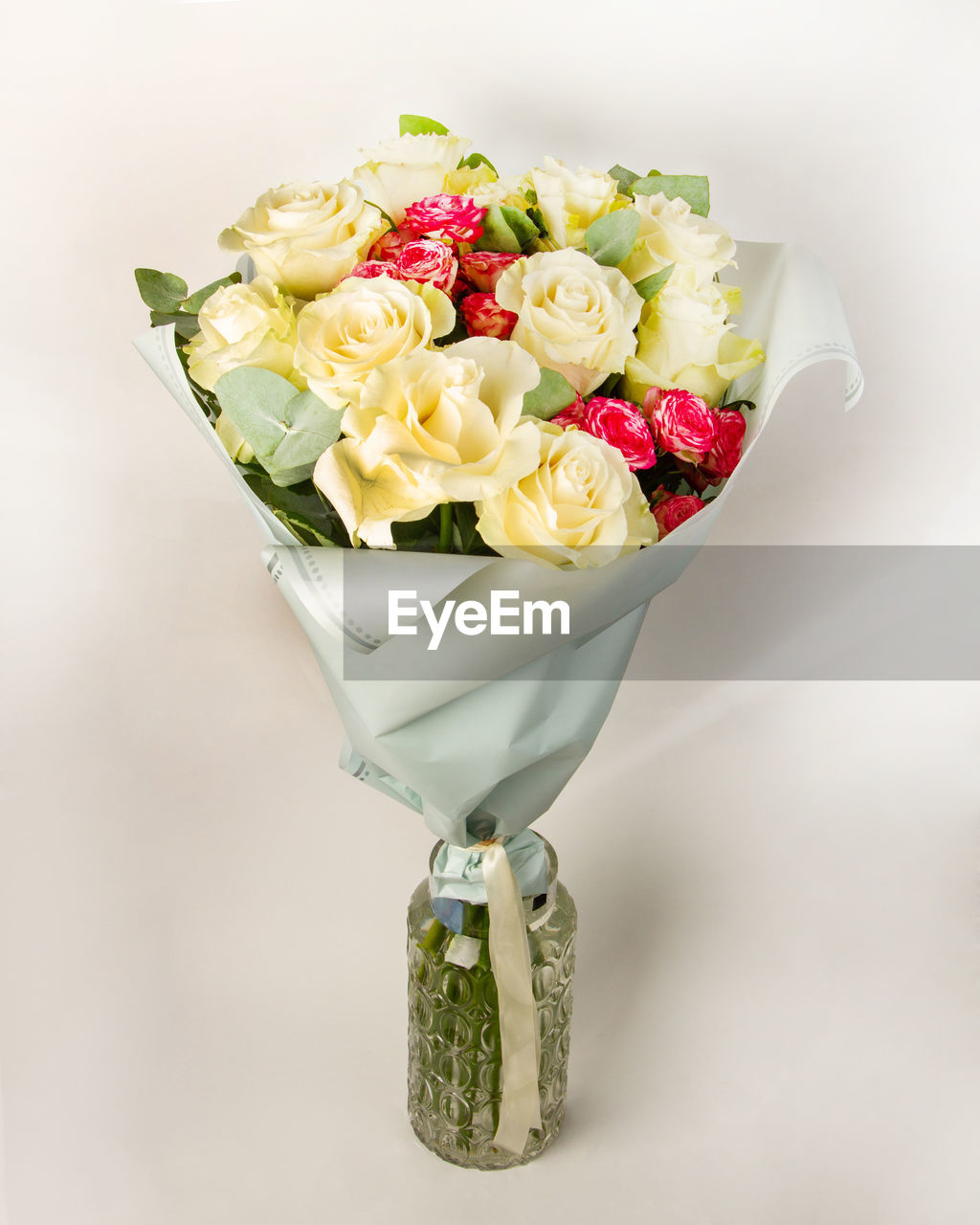 Close-up of rose bouquet in vase against white background