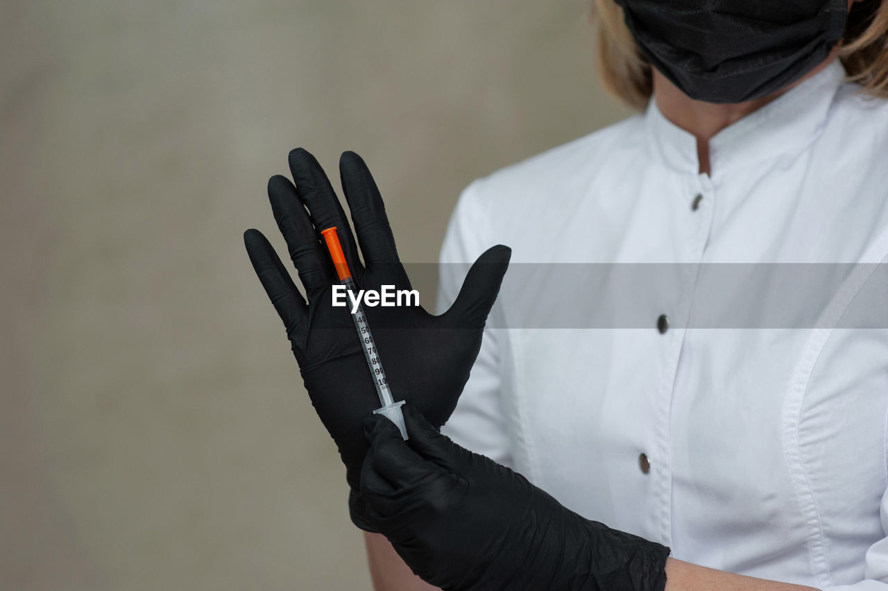 Midsection of doctor holding syringe