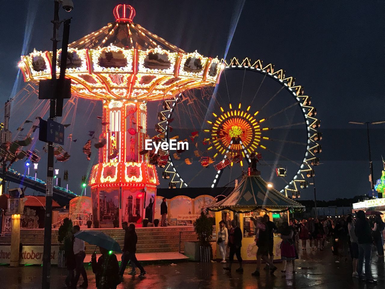 LOW ANGLE VIEW OF ILLUMINATED CAROUSEL AT NIGHT