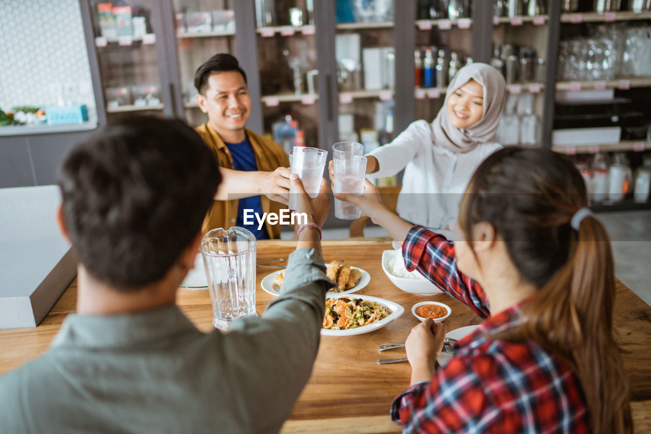 side view of mother and daughter sitting at table