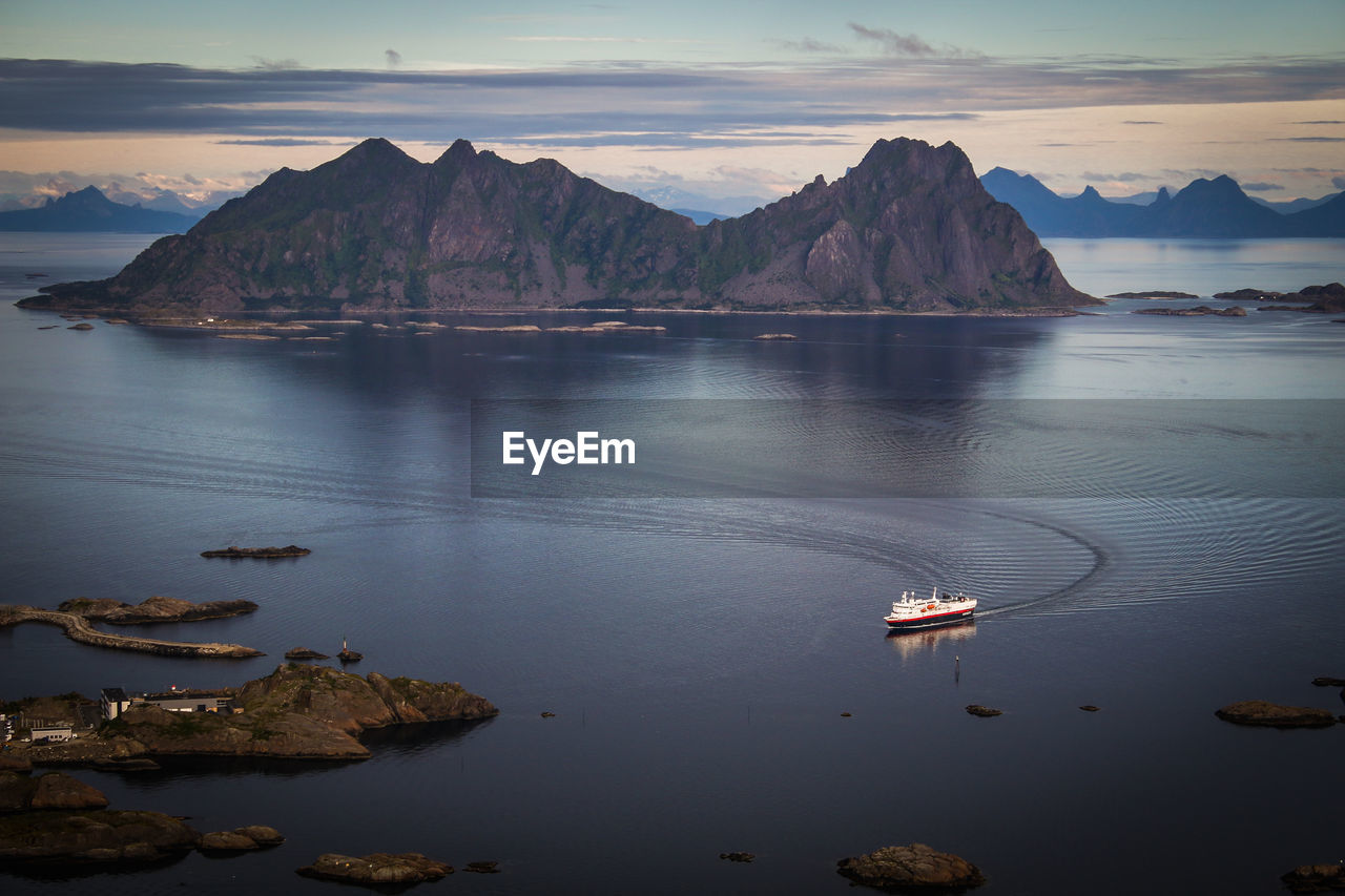 Scenic view of sea by mountains against sky