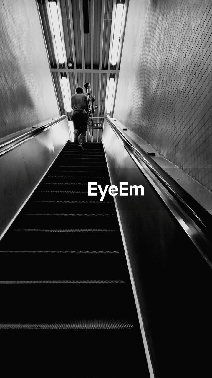 Low angle view of man walking on escalator