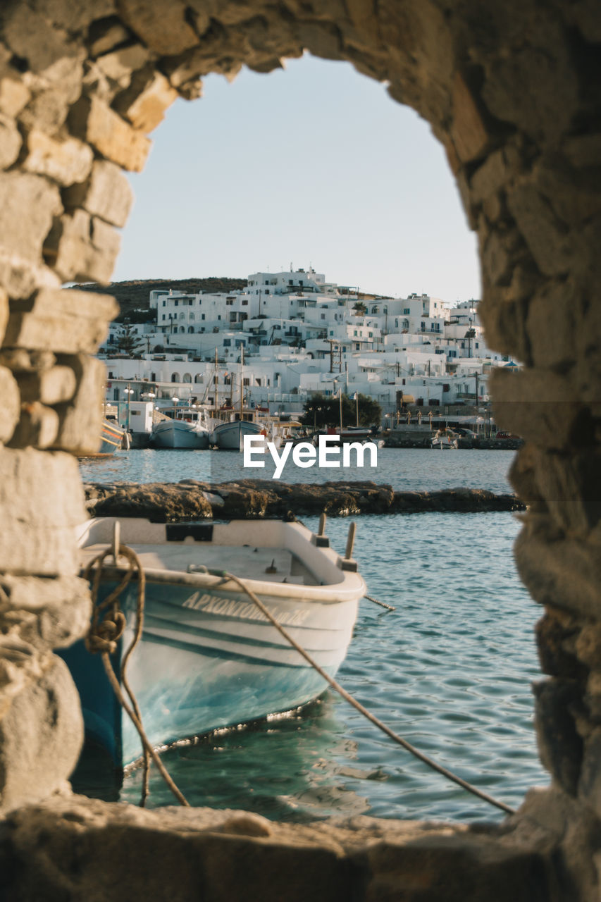 SAILBOATS IN SEA AGAINST BUILDINGS