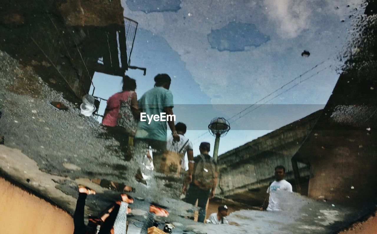 People walking reflection in water