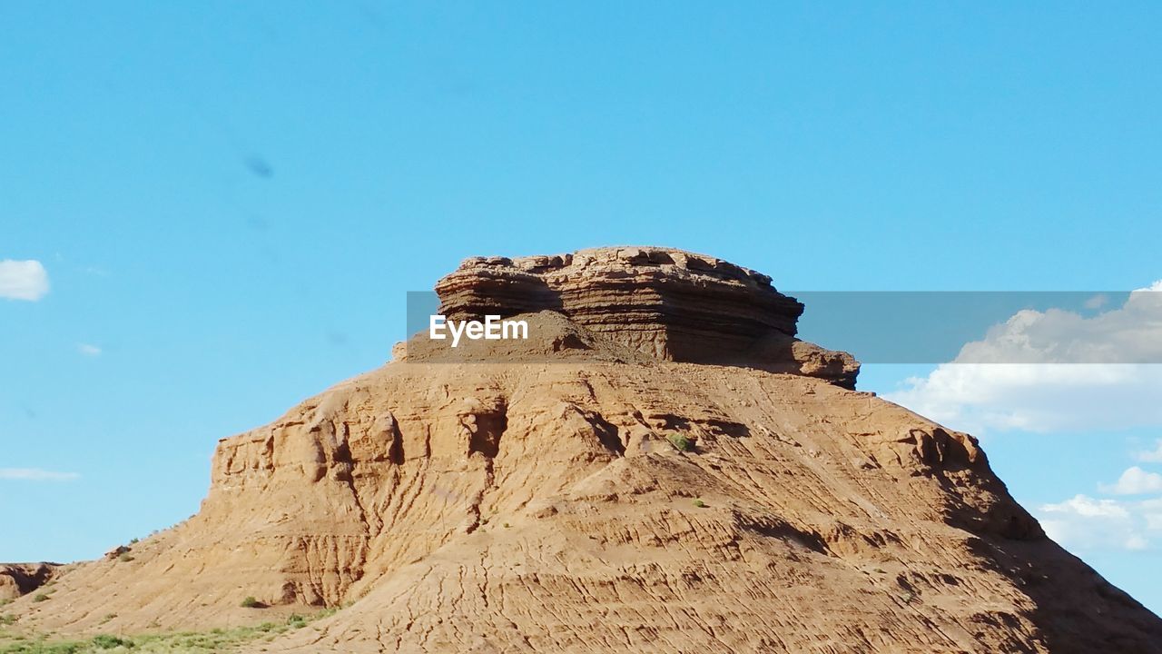 Low angle view of rock formation against sky on sunny day