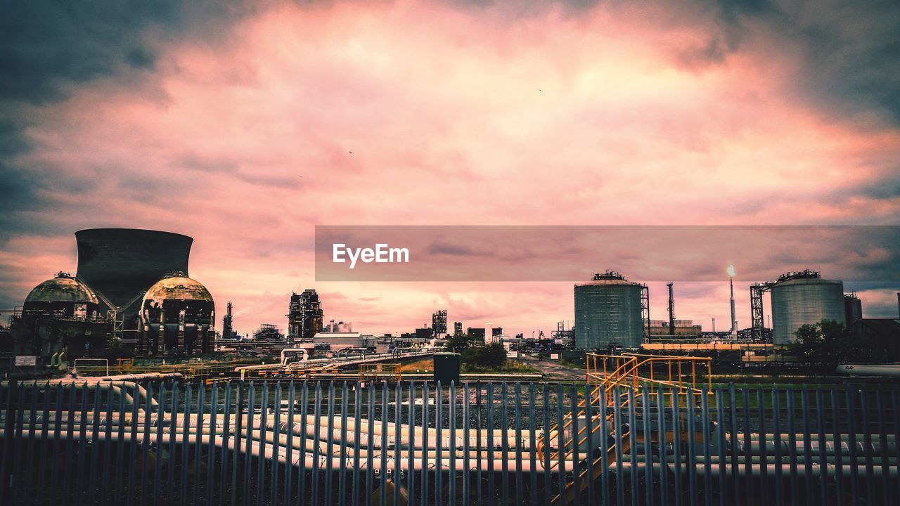 BUILDINGS IN CITY AGAINST SKY AT SUNSET