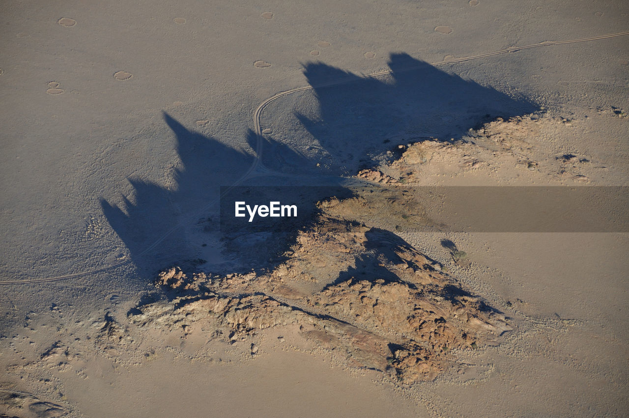 HIGH ANGLE VIEW OF FOOTPRINT ON BEACH