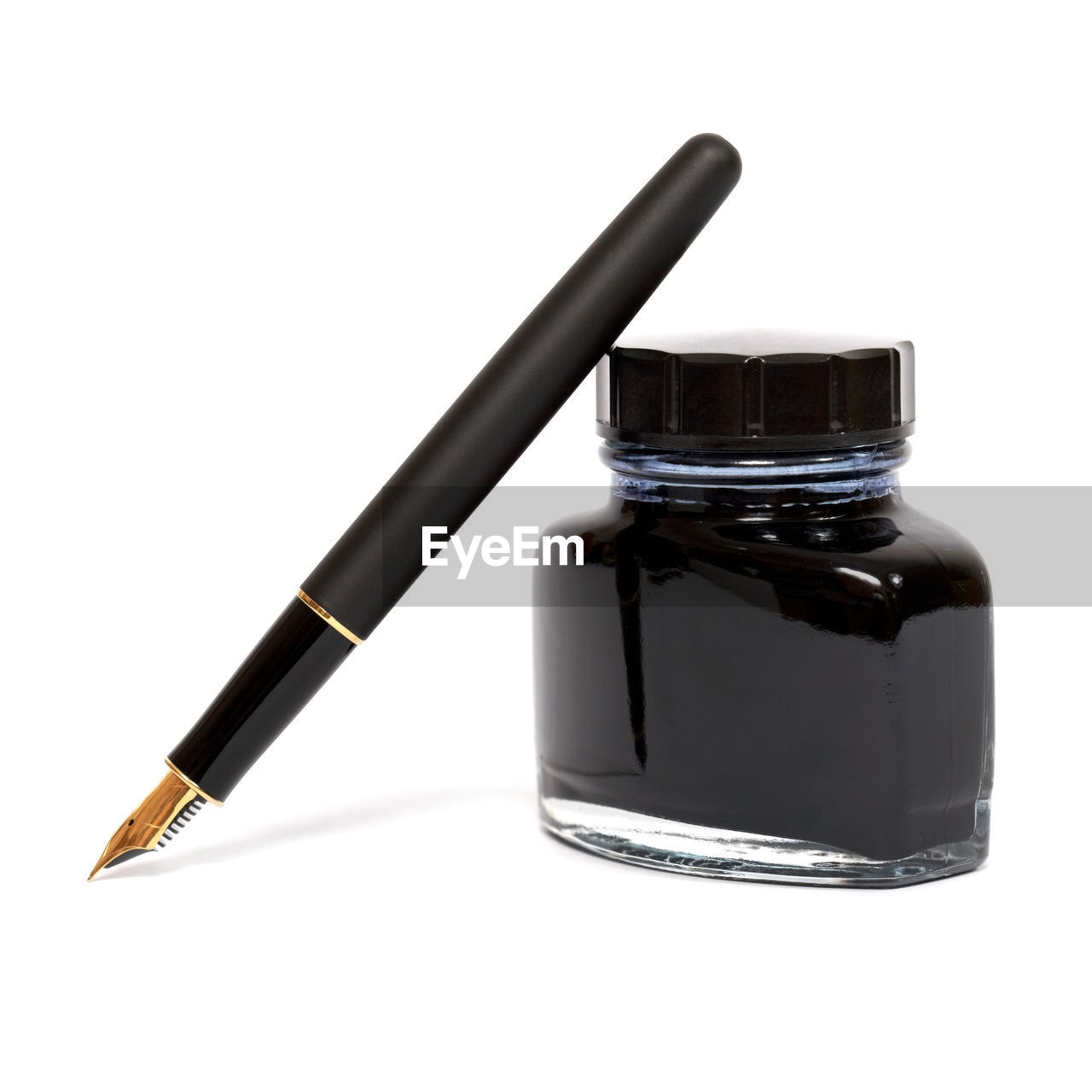 Close-up of pen and ink bottle on white background