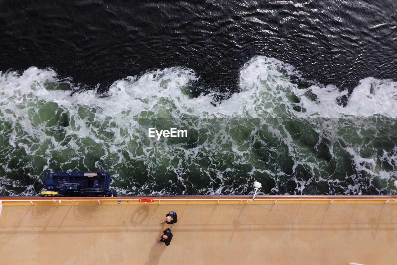 Directly above view of people walking on ferry deck in sea