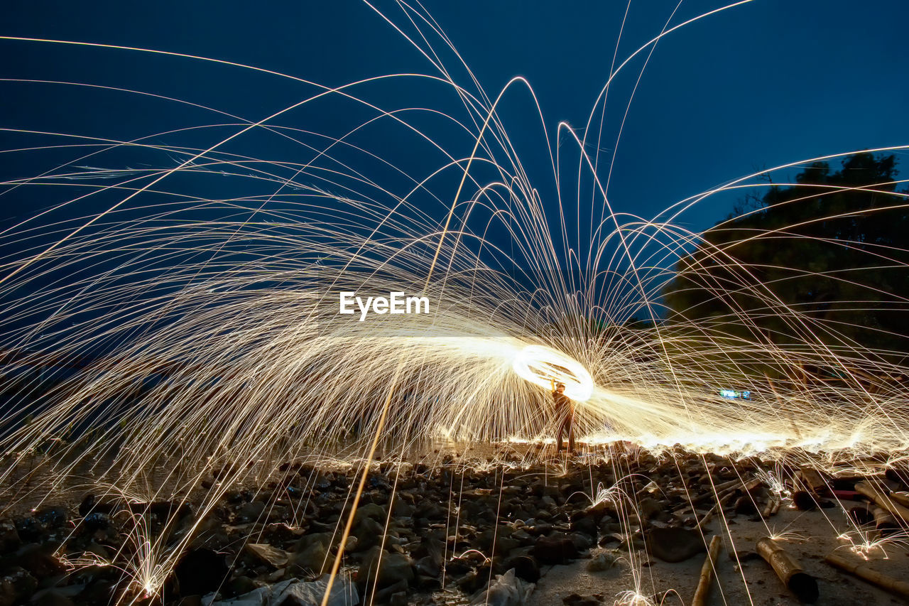 LIGHT TRAILS ON SKY AT NIGHT