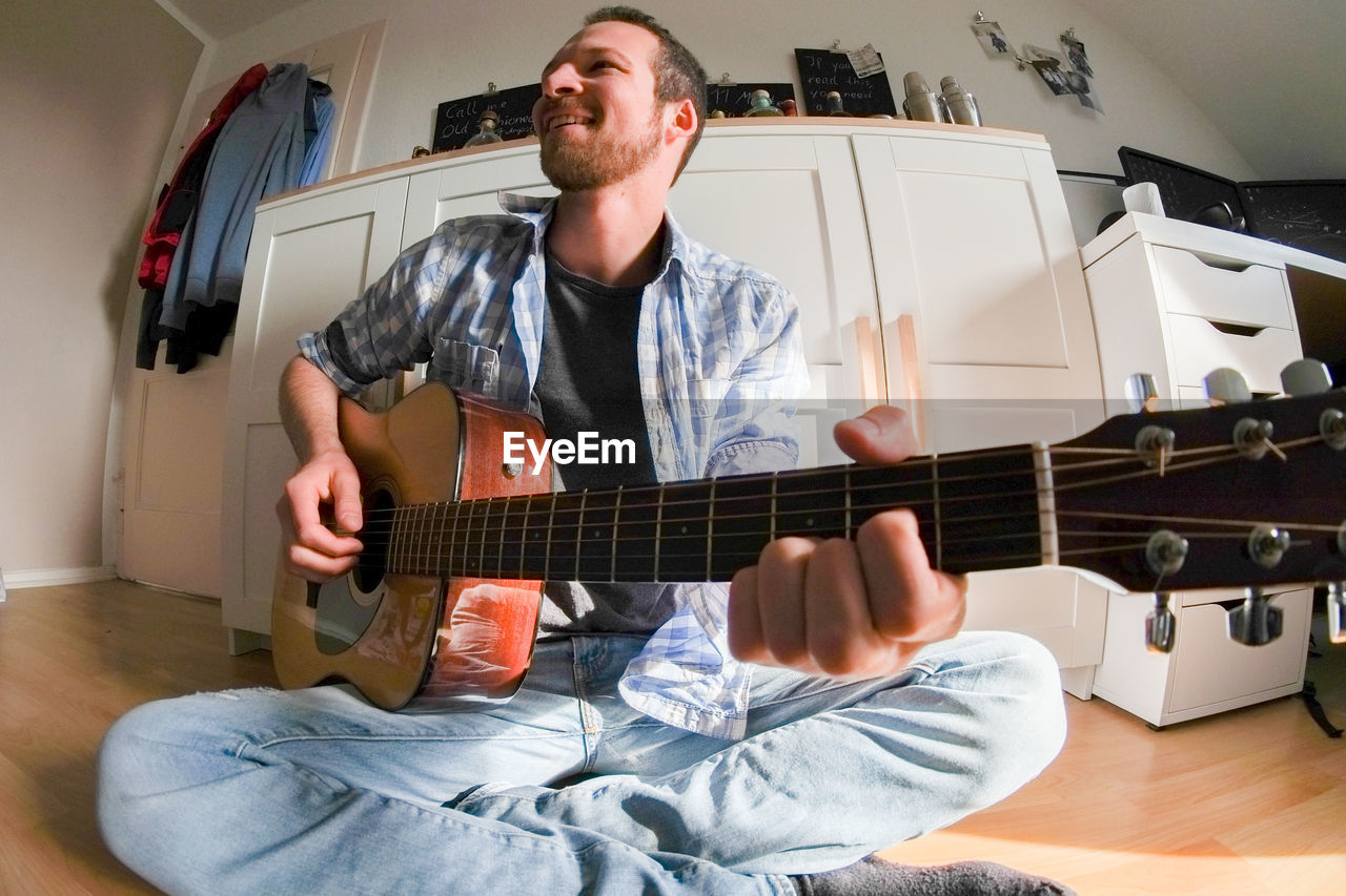 Man playing guitar at home