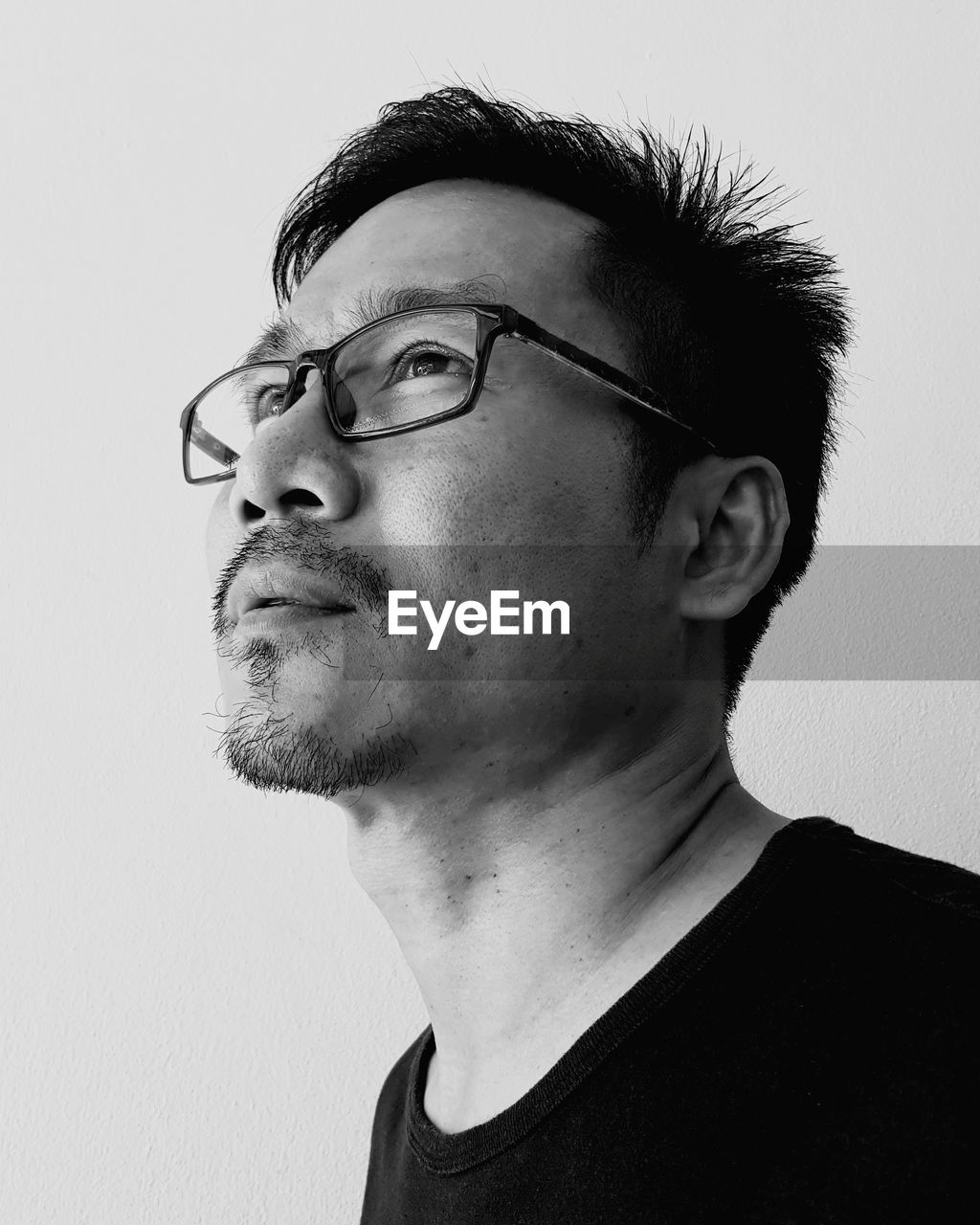 Portrait of young man wearing eyeglasses against white background