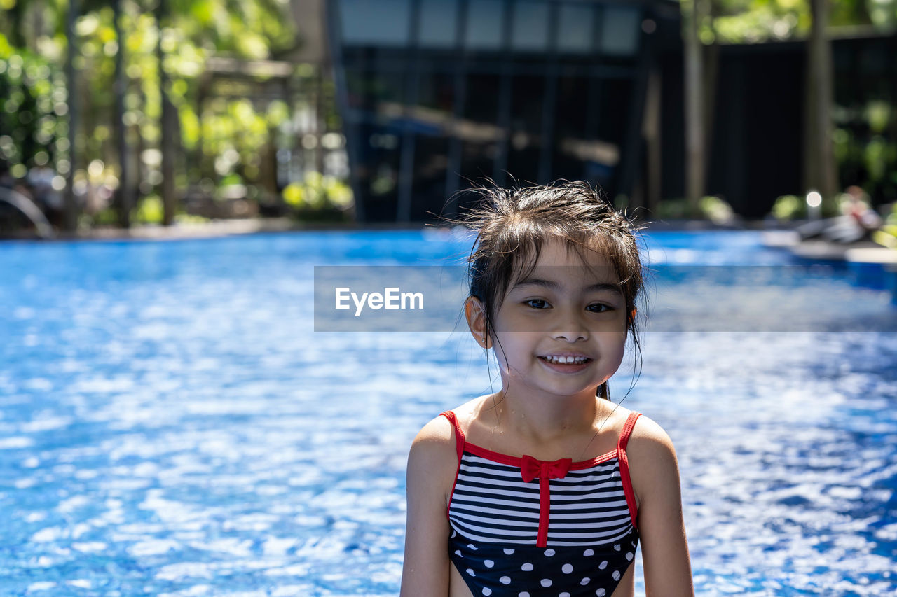 Portrait of girl by swimming pool