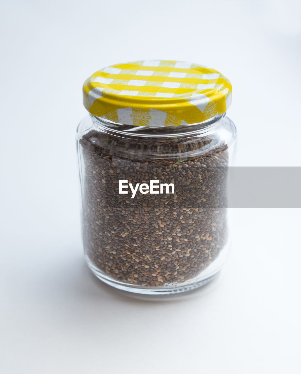 Close-up of chia seeds in jar over white background