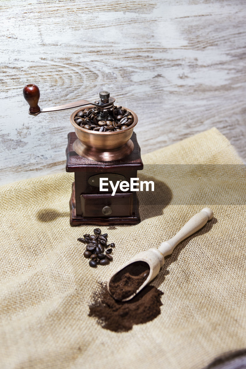 HIGH ANGLE VIEW OF VINTAGE CAMERA ON TABLE WITH HANDS