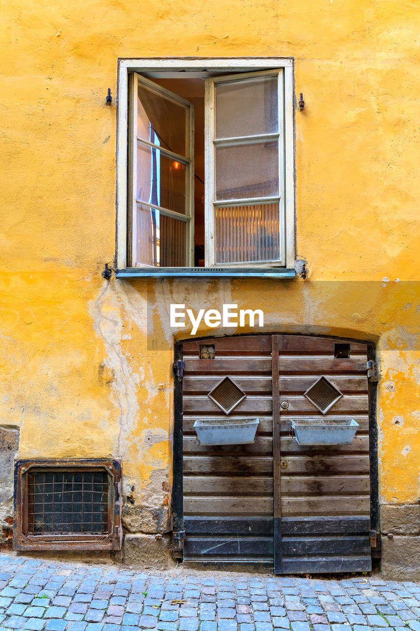 architecture, building exterior, built structure, window, building, yellow, no people, wall, residential district, door, facade, entrance, city, wall - building feature, wood, closed, house, old, day, brick, outdoors, street, weathered, history, protection, home, security