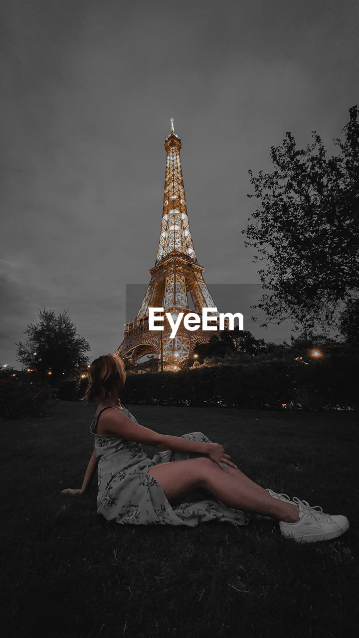 WOMAN SITTING ON TOP OF BUILDING