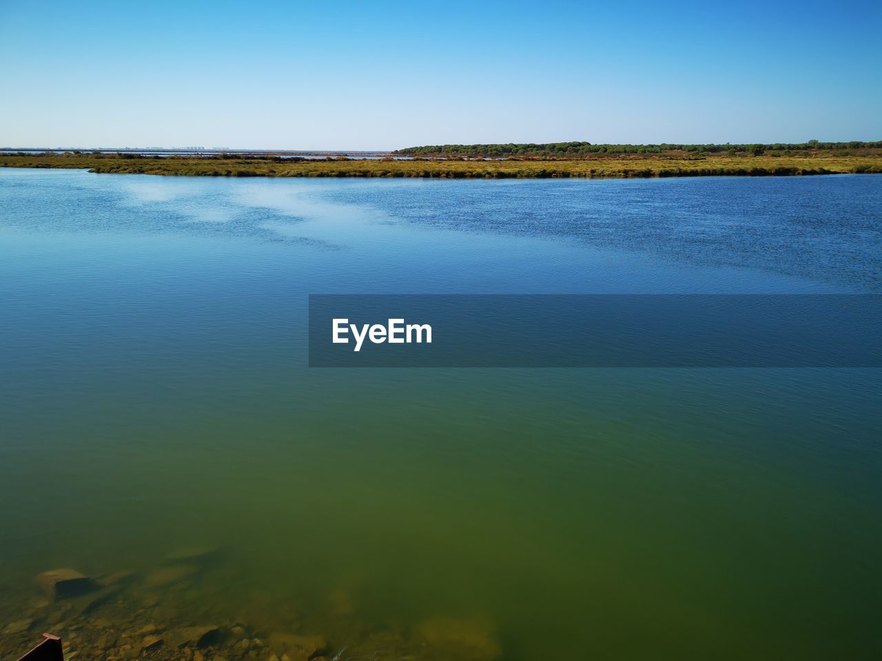 SCENIC VIEW OF LAKE AGAINST BLUE SKY