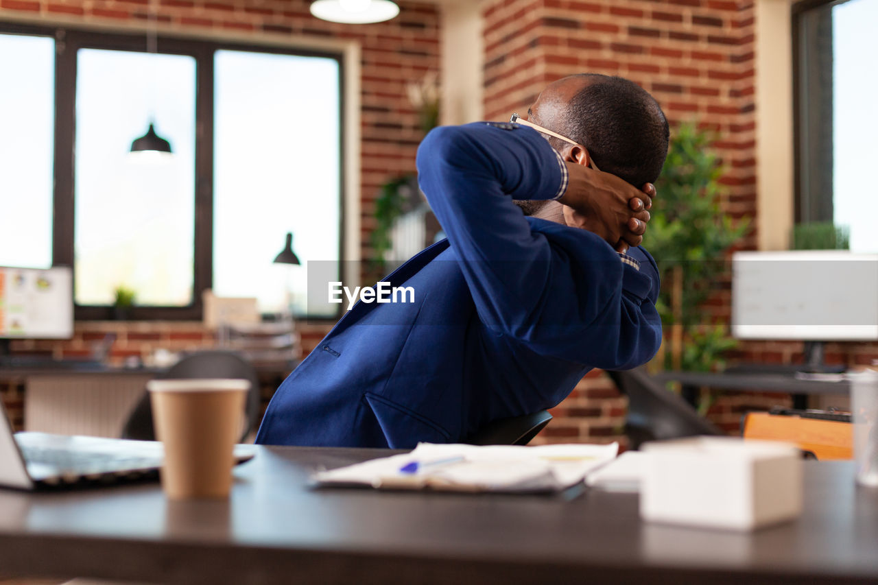 Side view of man working at table