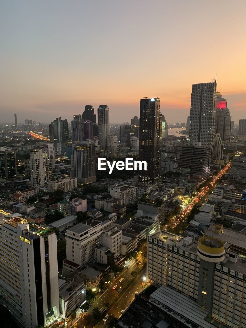 HIGH ANGLE VIEW OF ILLUMINATED BUILDINGS IN CITY AGAINST SKY