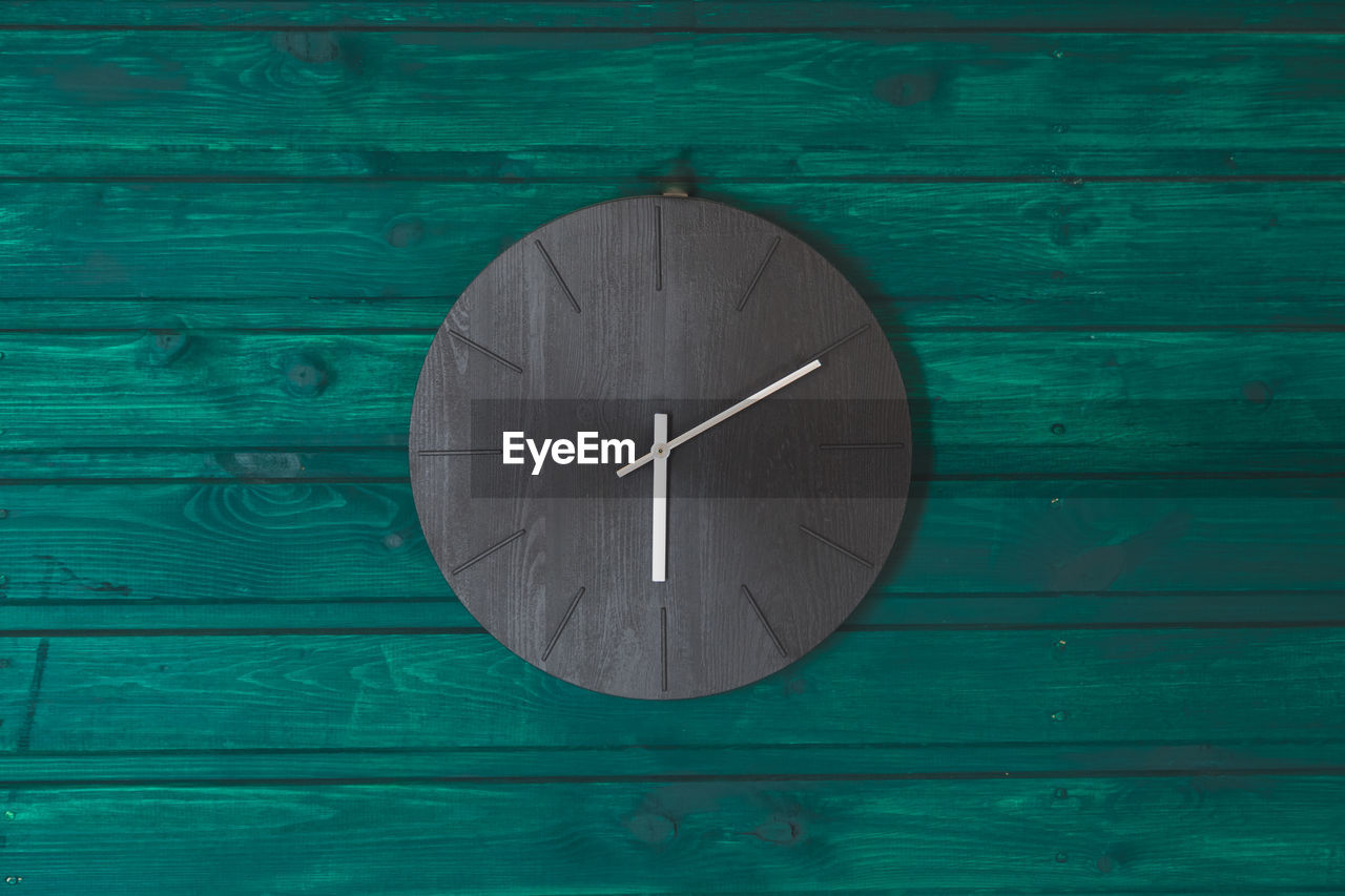 Close-up of clock on wooden wall