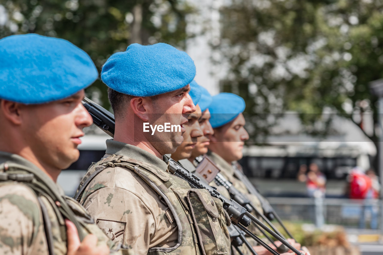 GROUP OF YOUNG MAN WEARING MASK AGAINST BLUE SKY