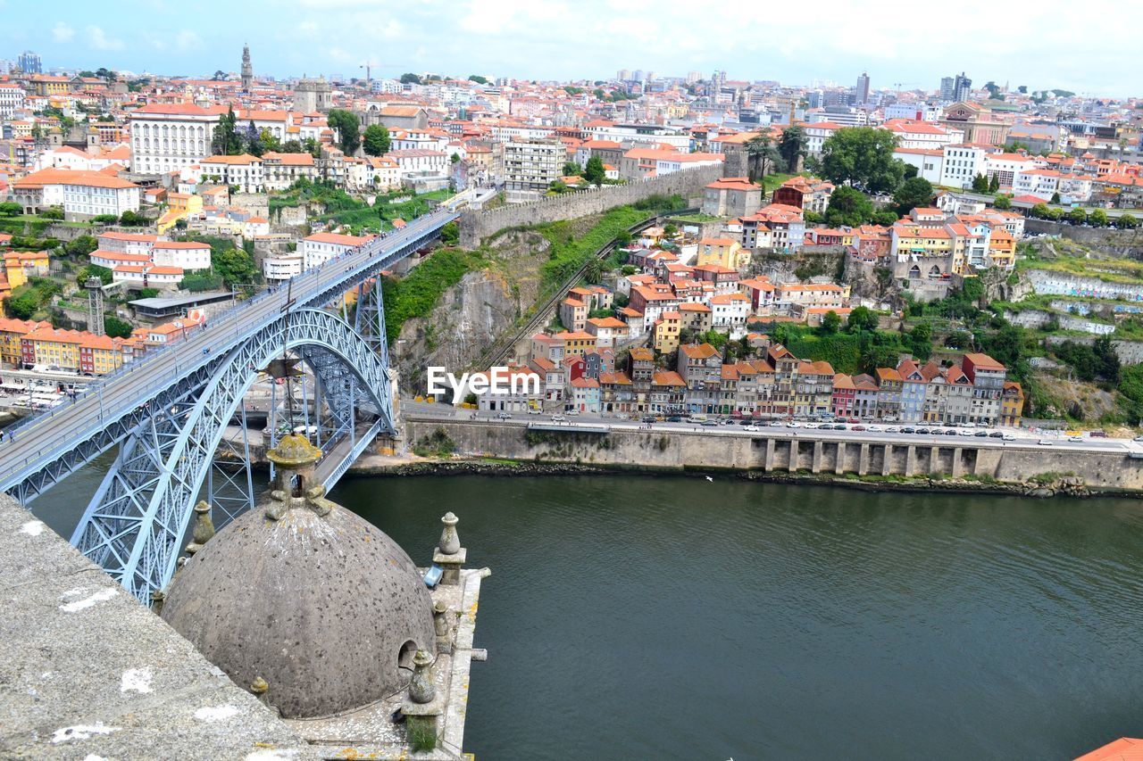 ARCH BRIDGE OVER RIVER BY BUILDINGS IN CITY