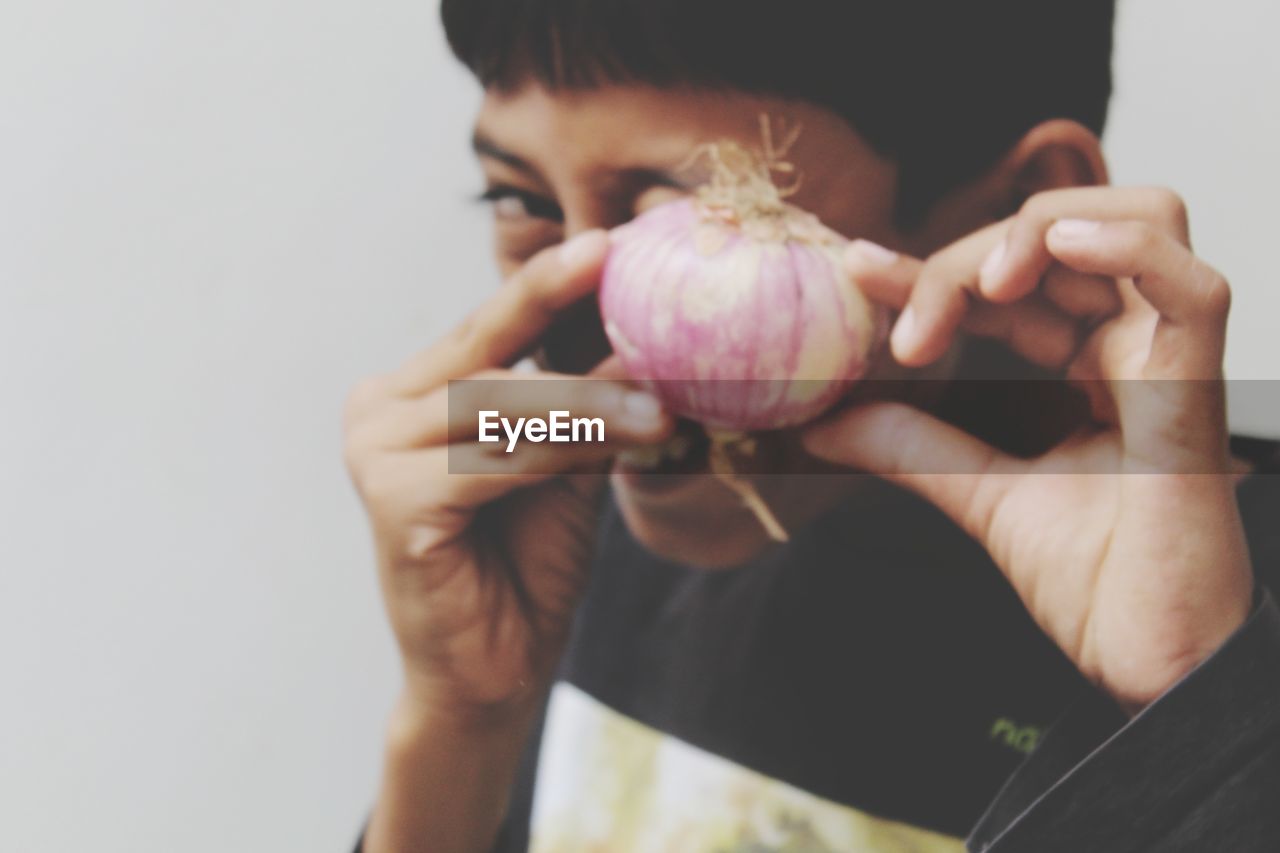 Close-up of boy holding onion