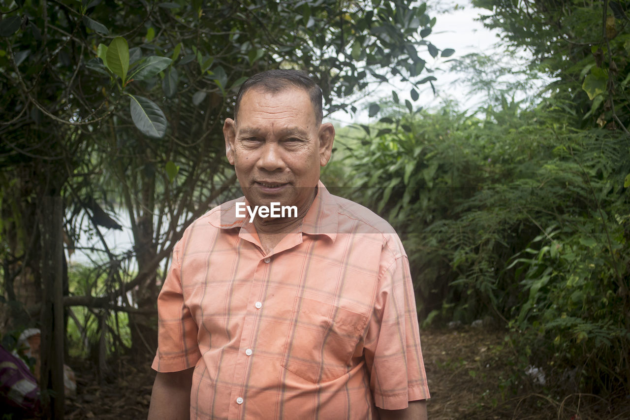 Senior man standing by in forest