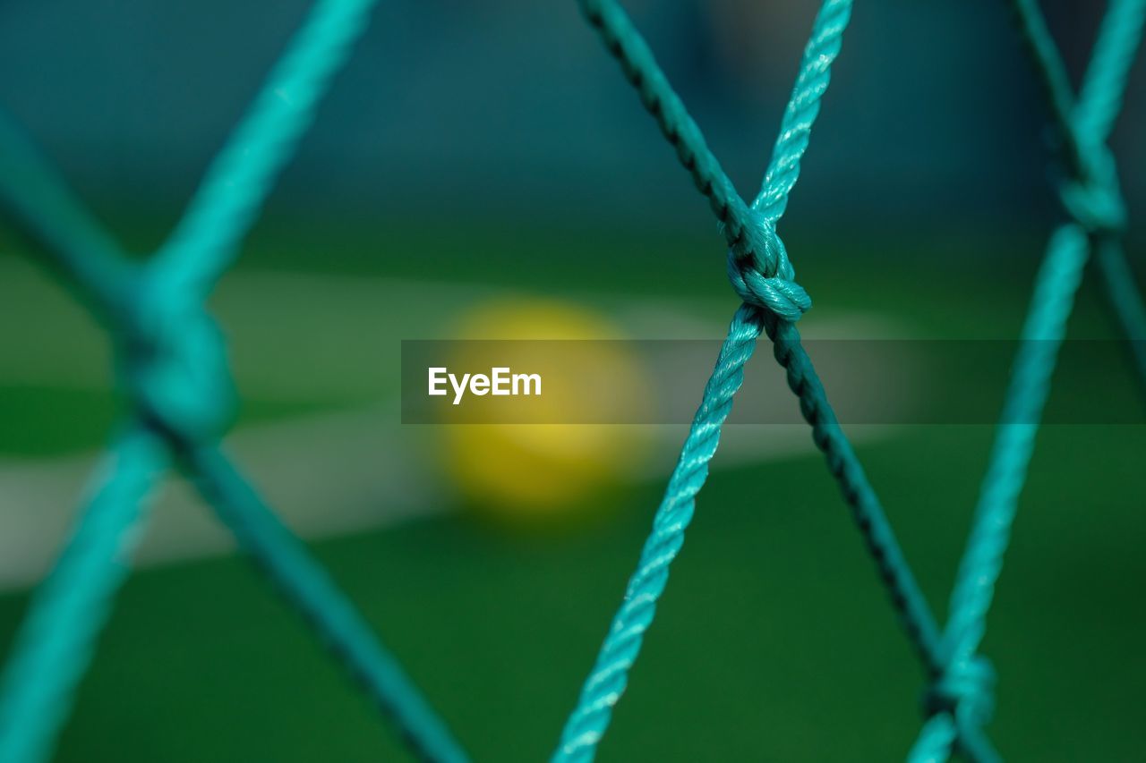 CLOSE-UP OF ROPE TIED UP ON FENCE