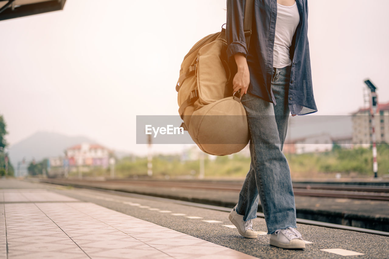 LOW SECTION OF MAN WALKING ON RAILROAD TRACKS