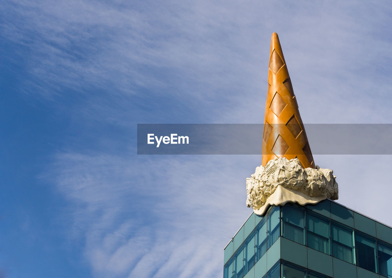 Low angle view of ice cream cone sculpture on building against sky