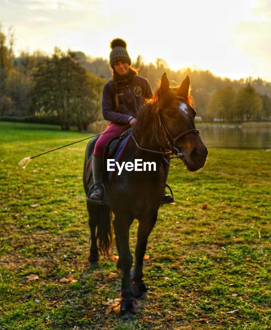 Woman riding horse on field against sky