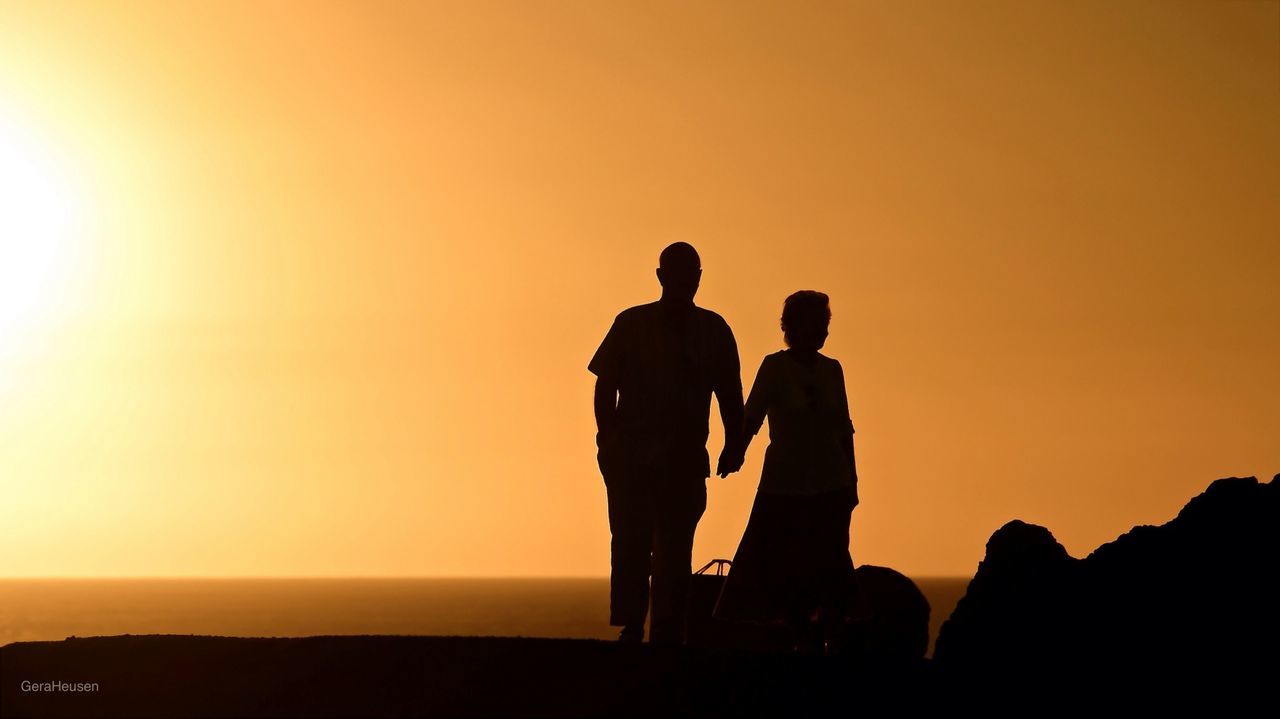 Silhouette couple against clear sky during sunset