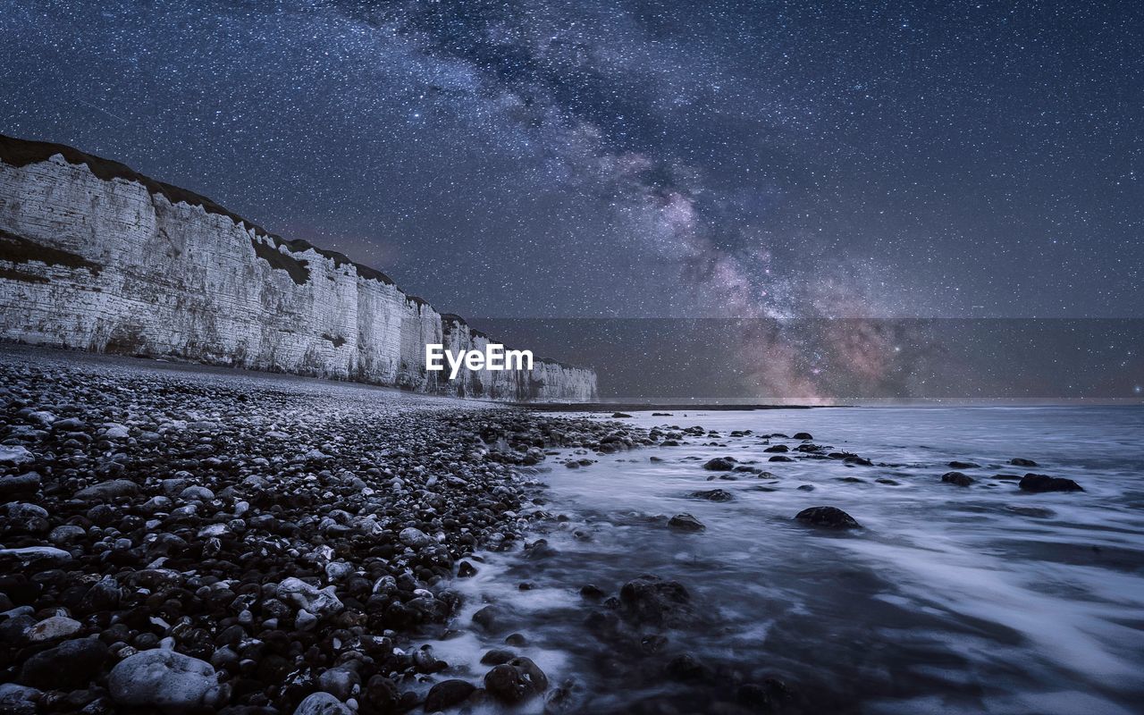 Scenic view of sea against star field at night