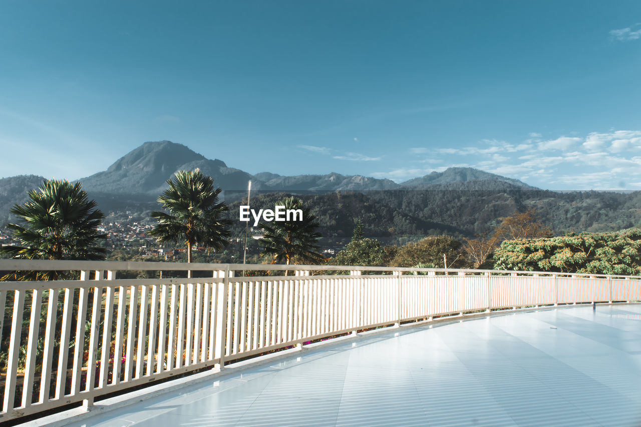 RAILING BY MOUNTAINS AGAINST SKY