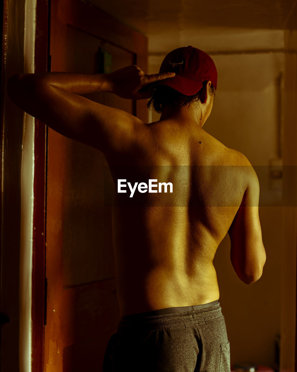 Rear view of shirtless man standing at home