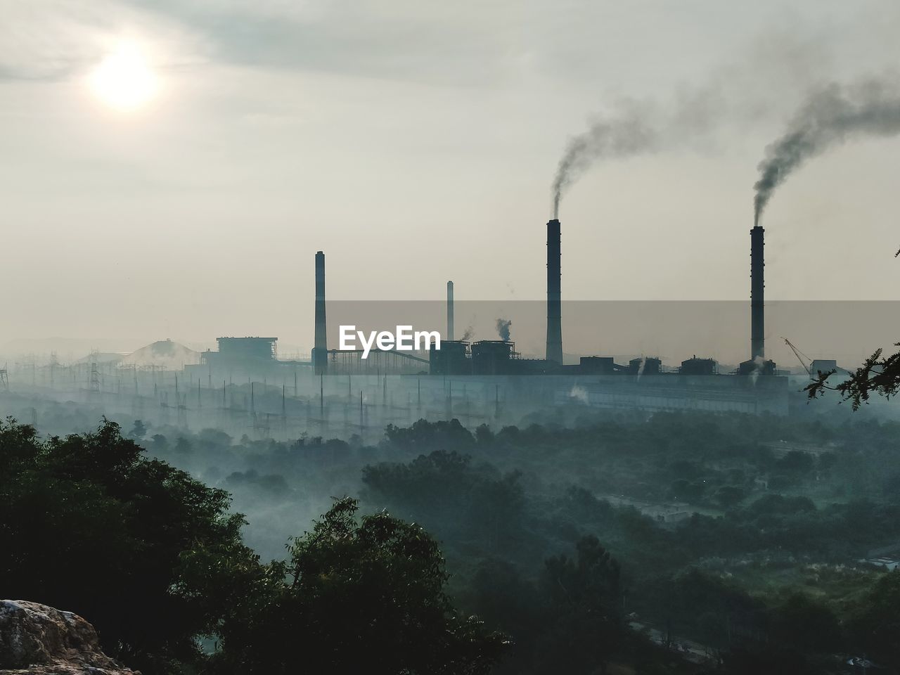 Smoke emitting from chimney against sky