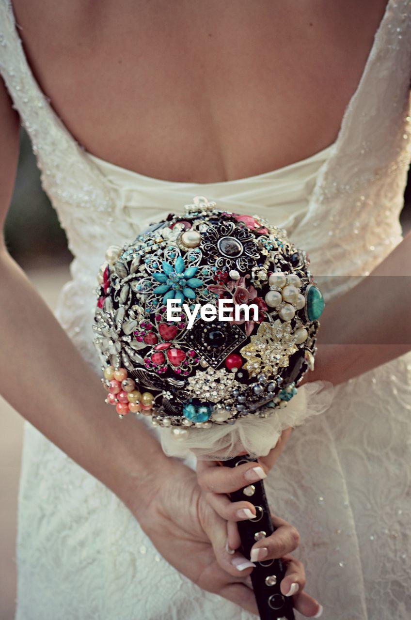 Midsection of woman holding artificial bouquet