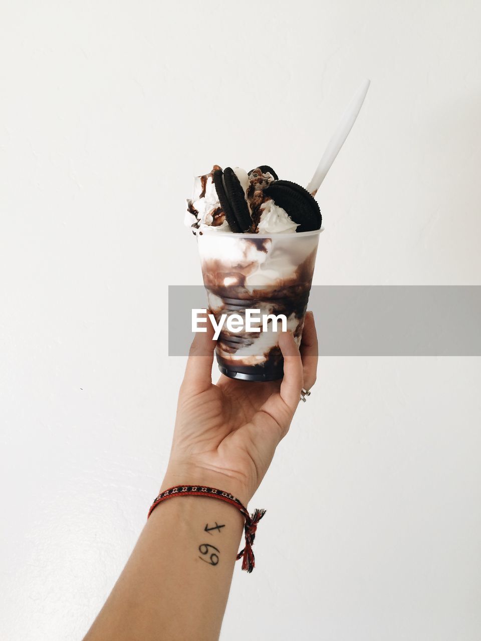 Hand holding ice cream against white background