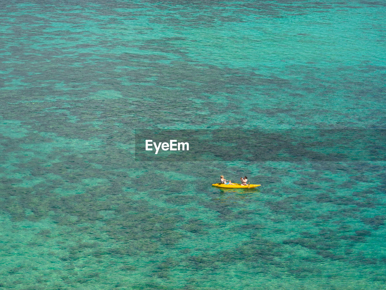 High angle view of women sitting canoe at sea