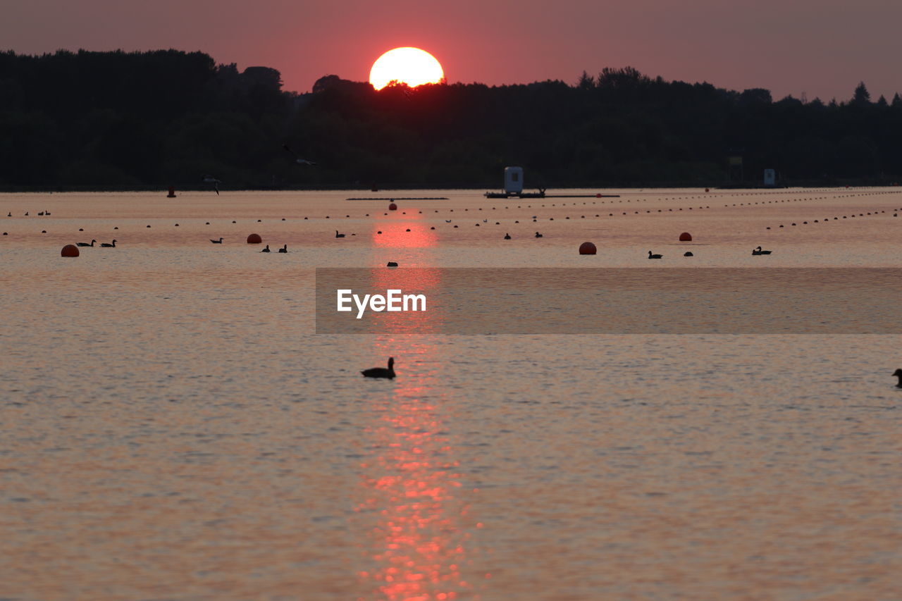 SCENIC VIEW OF BEACH AGAINST SKY AT SUNSET